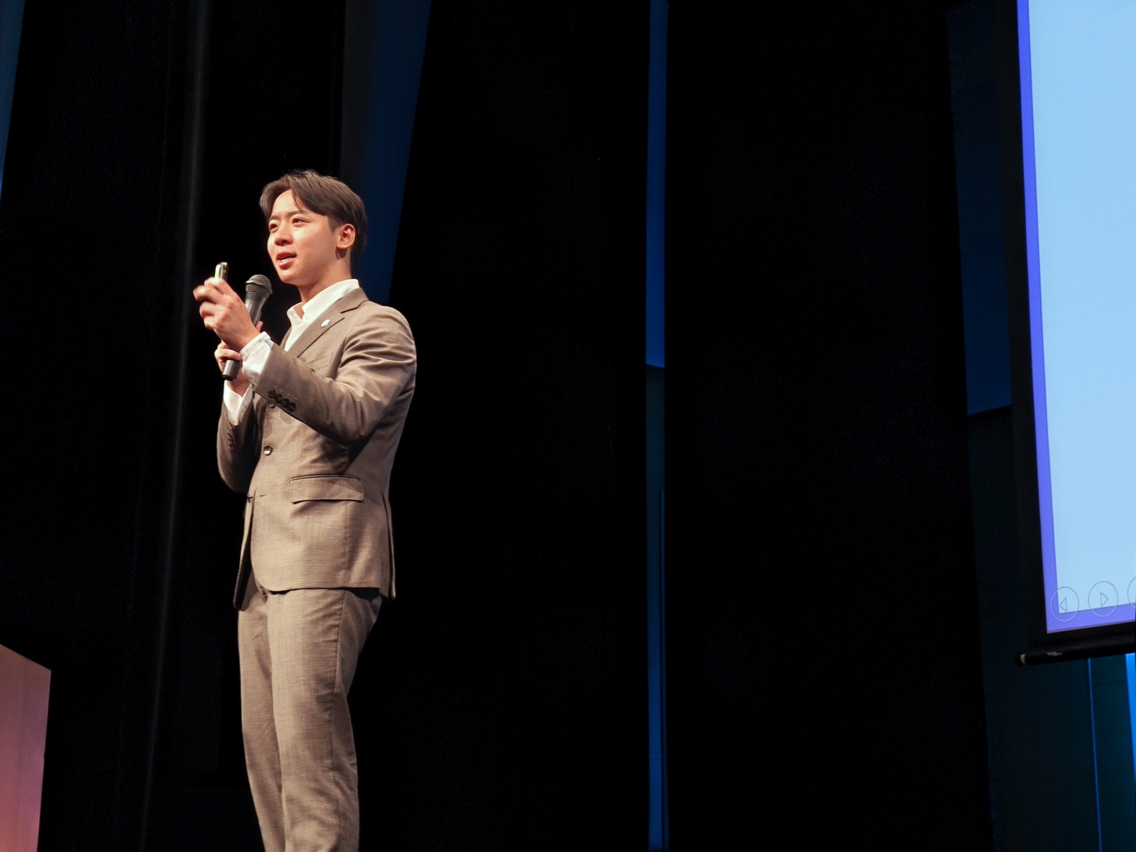 マイクを手にステージで登壇する日本AI開発センター株式会社 代表取締役CEO 中尾香達